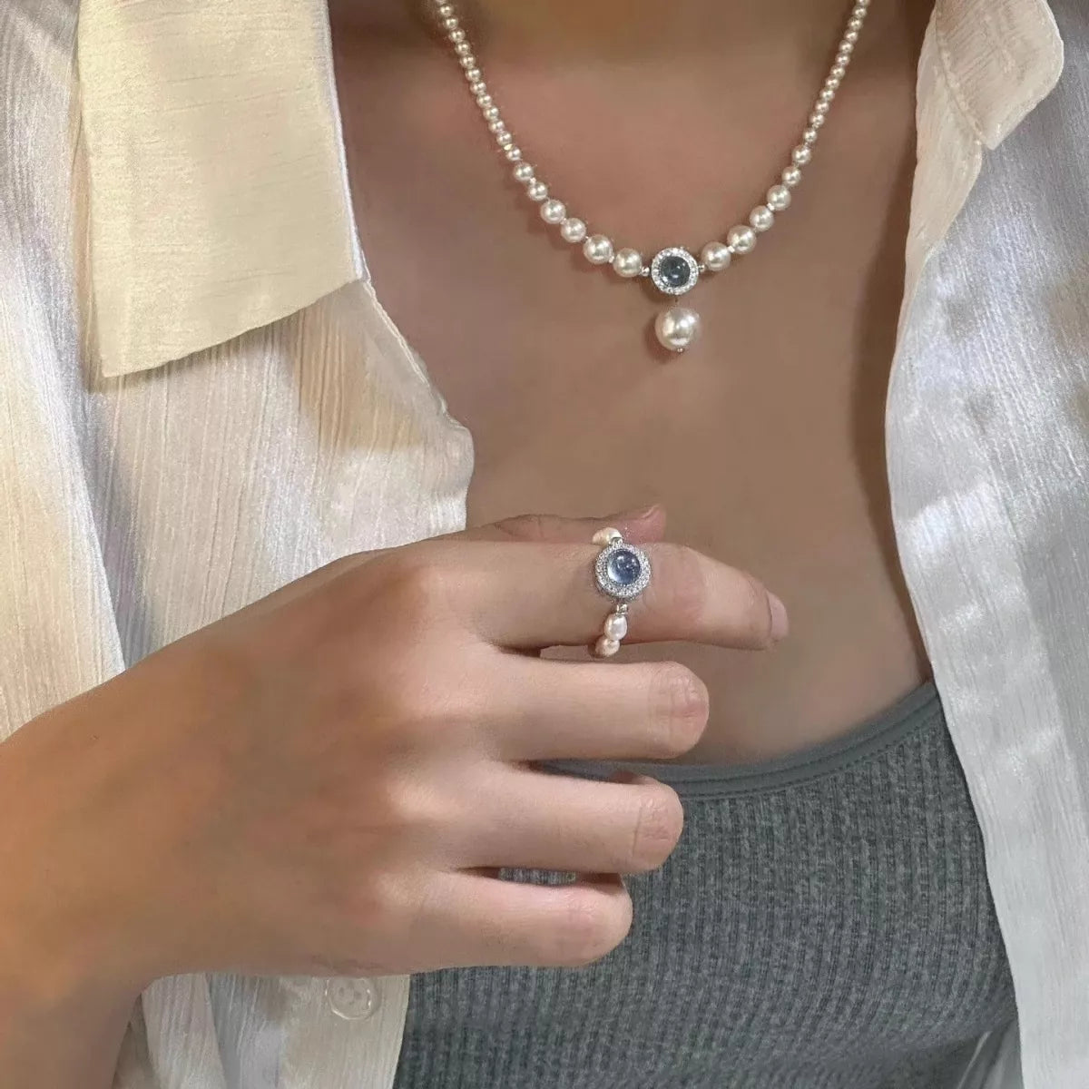 Detail shot of synthetic pearl luster and natural stone texture in sterling silver setting