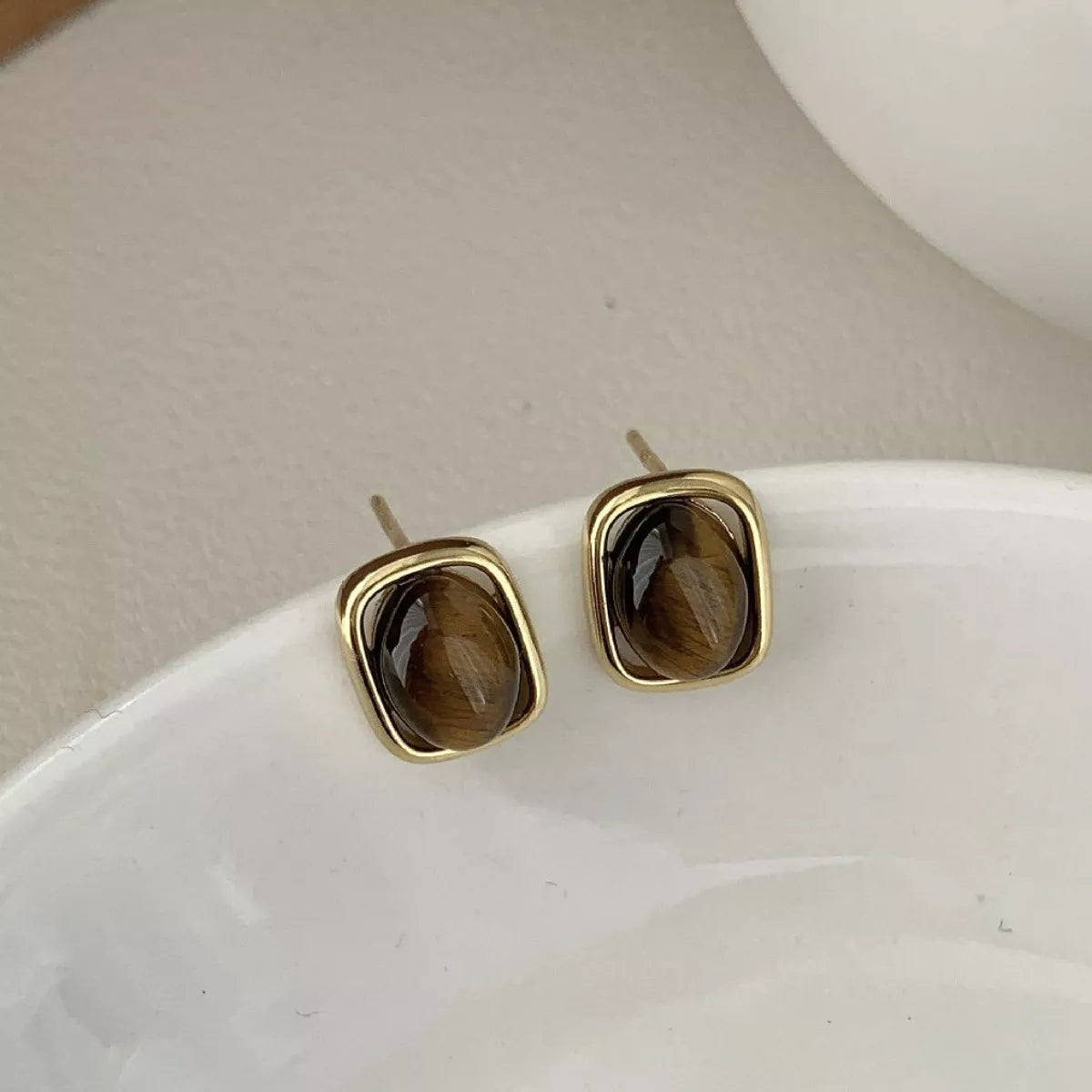 Close-up square tiger eye gemstone studs 925 sterling silver gold plated showing natural chatoyancy