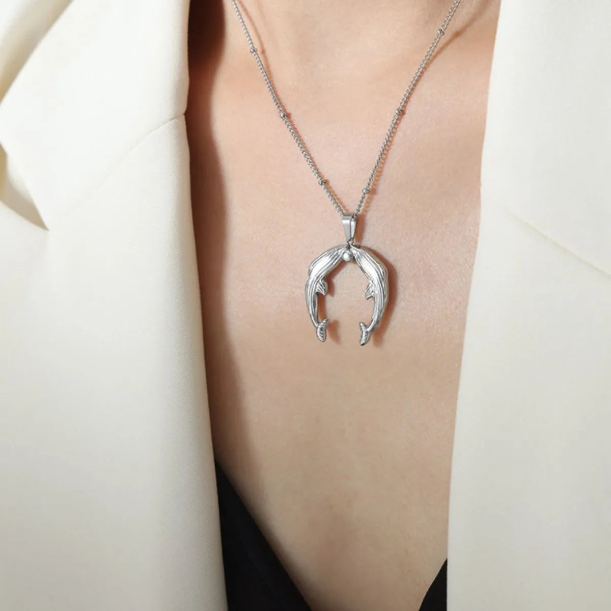 Kissing Dolphins Silver Plated Necklace on Models Neckline Closeup | Rebellious Gal Jewelry