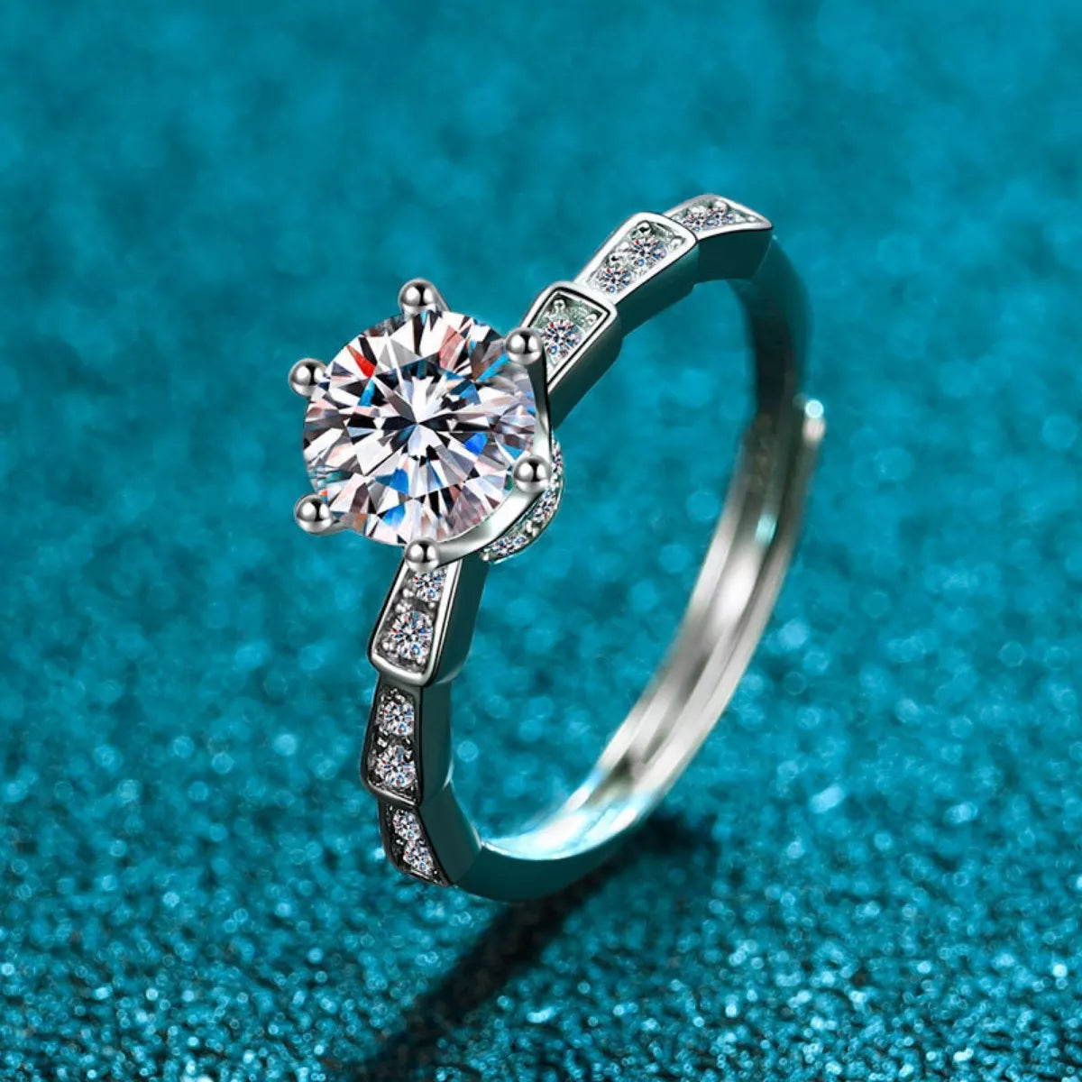 Silver ring with a large diamond on a blue textured background