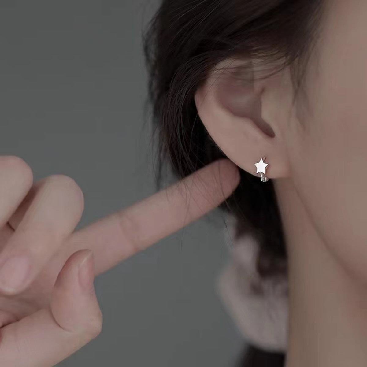 Model wearing Rebellious Gal star earrings with rebellious layered ear stack