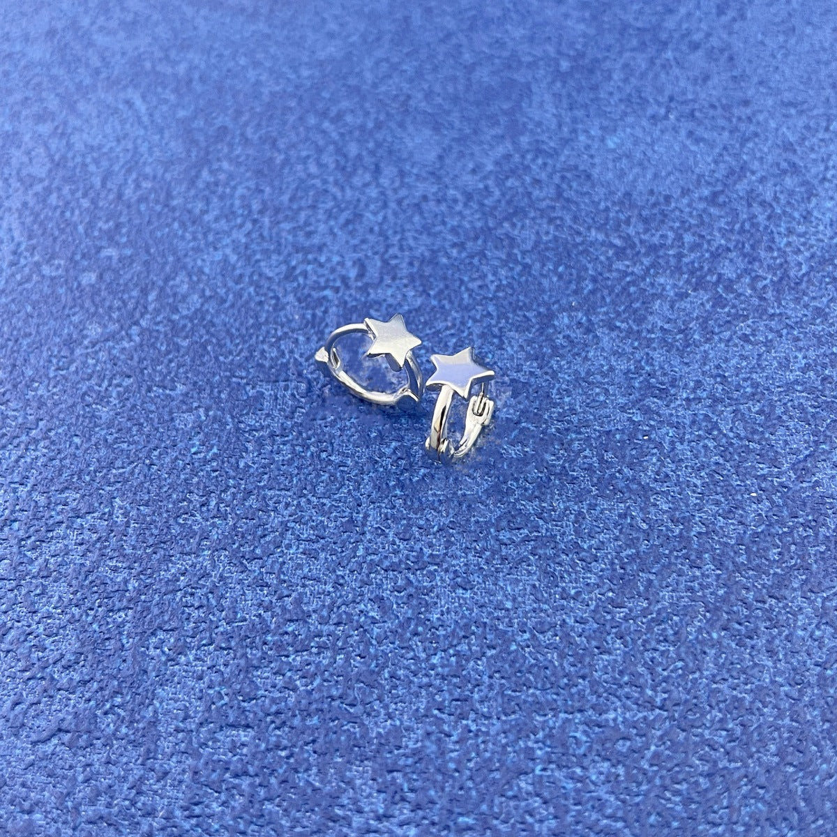 Rebellious Gal 925 sterling silver star earrings front view on blue background