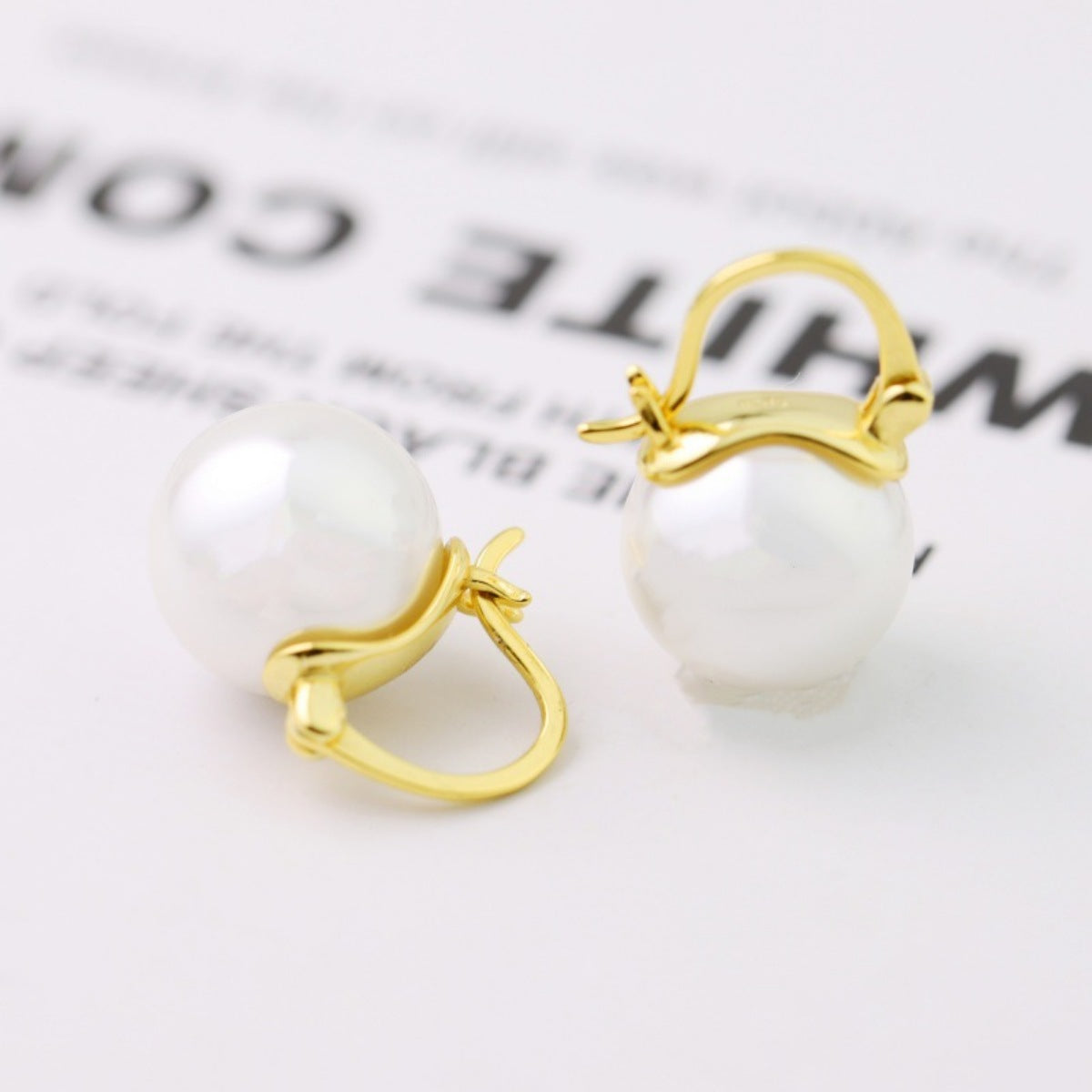 Side profile of delicate 0.4" pearl drop earrings showing drop length