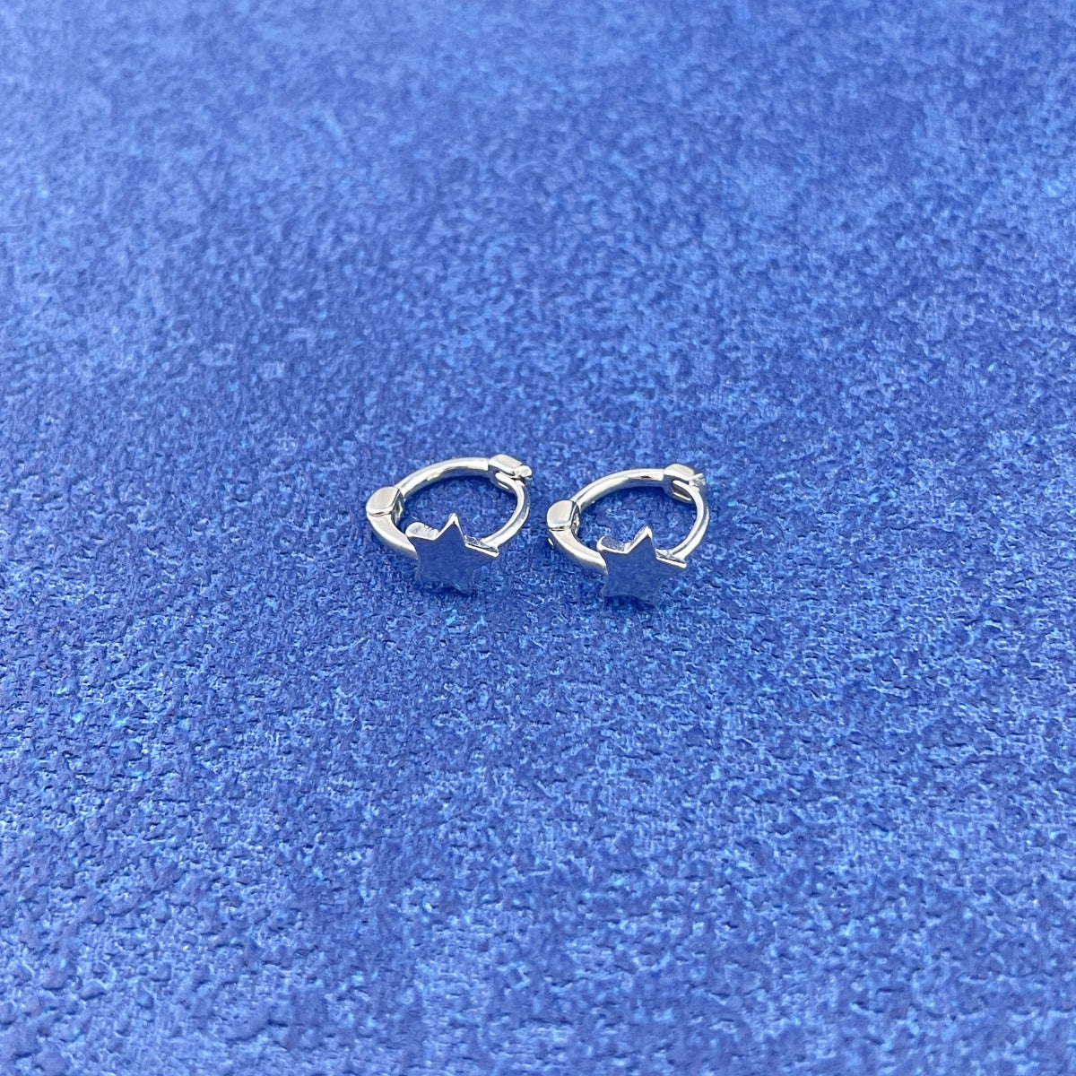 Close-up of delicate star charm on 925 sterling silver drop earrings