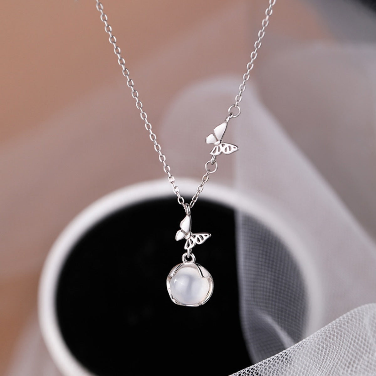 butterfly pearl pendant necklace in silver close up image 