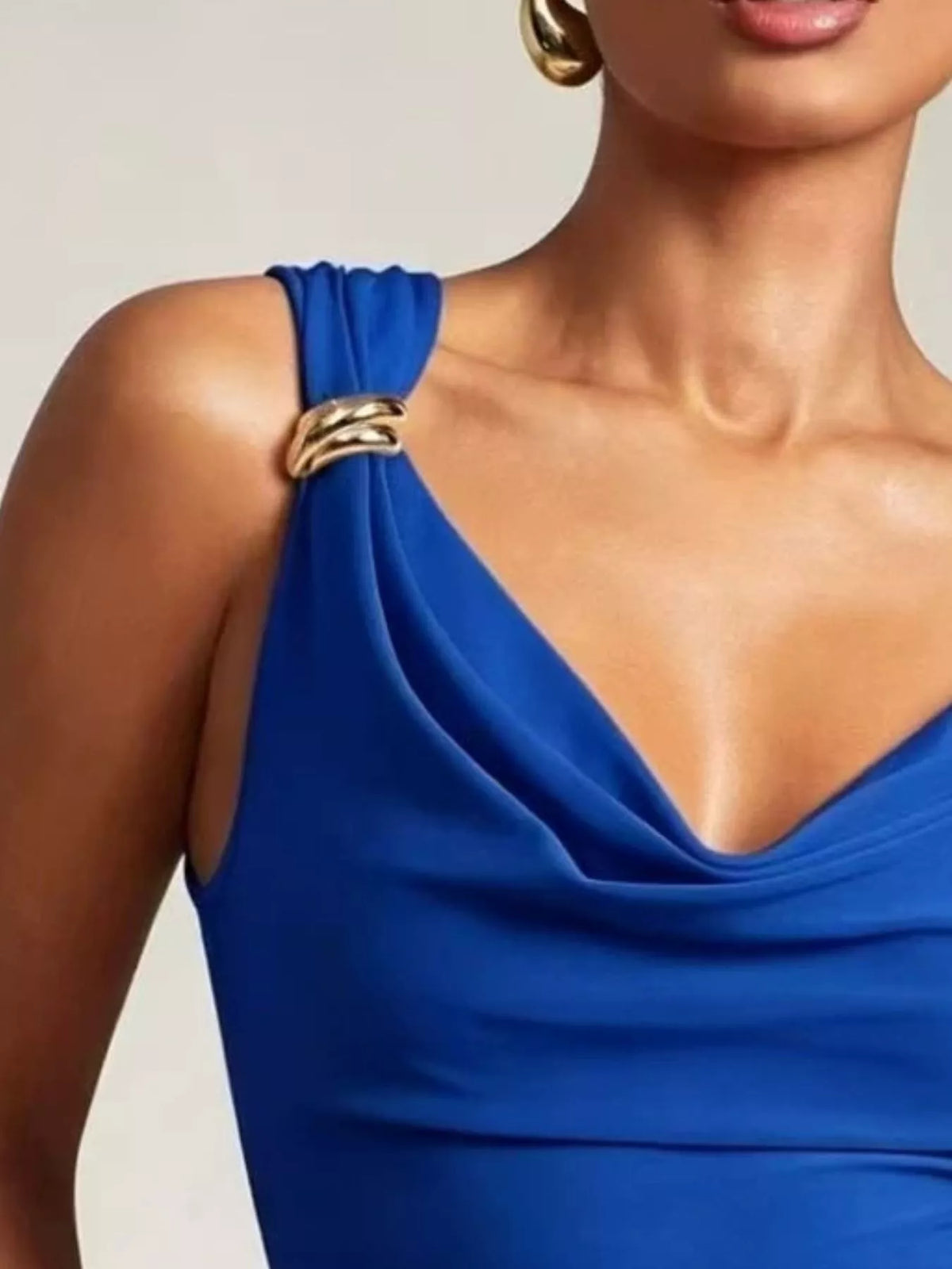 Blue dress with gold straps on a neutral background