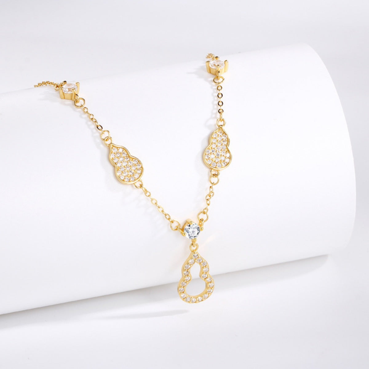 Gold necklace with heart-shaped links on a white background