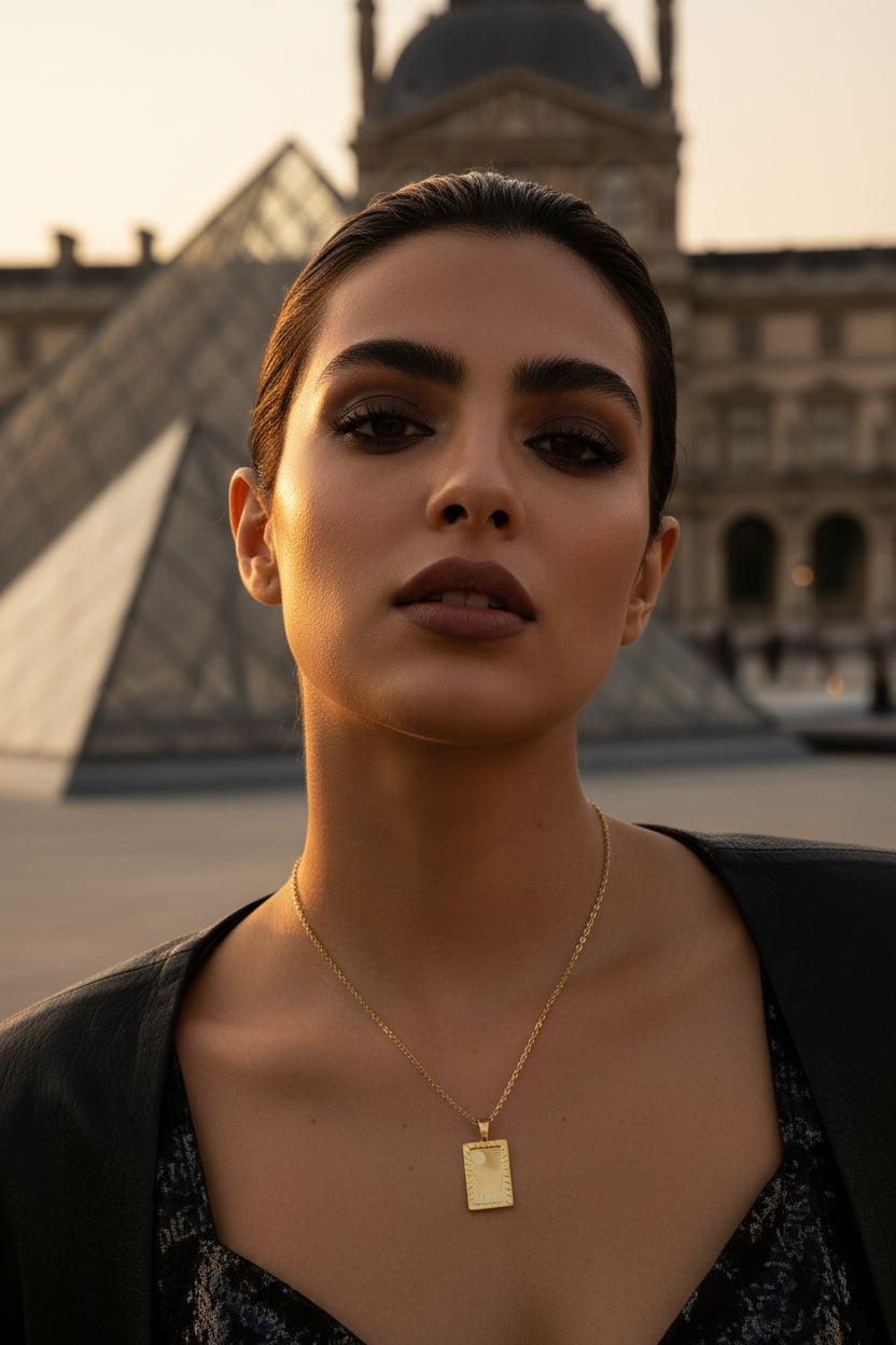 Gold necklace with a rectangular pendant on a model in Paris