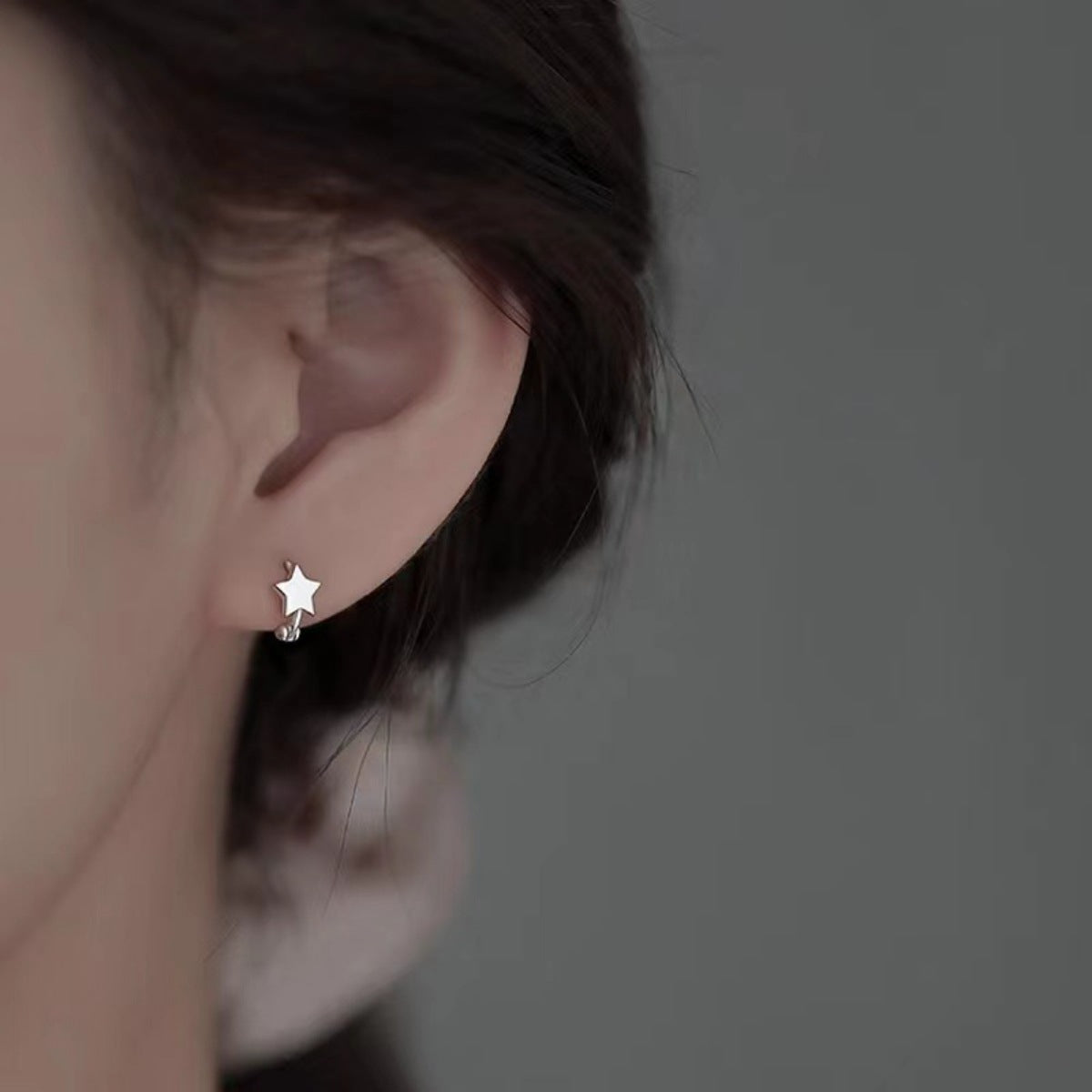 Model showing multiple piercings stacked with the delicate star drops