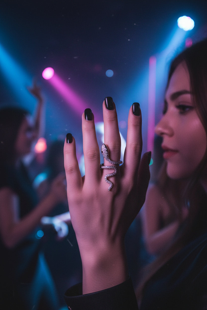 Silver snake-shaped ring with gemstones on models finger