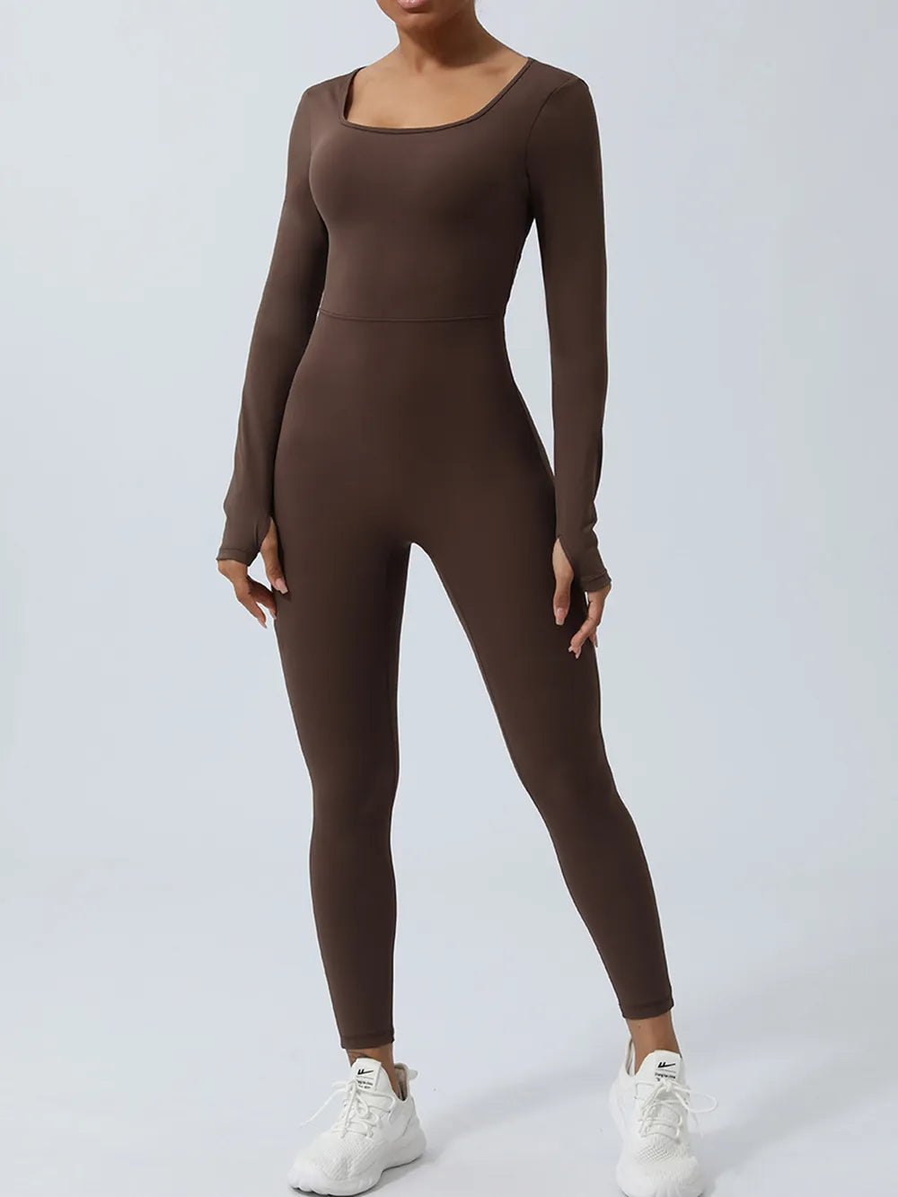 Chocolate brown colorway shown front on, arms hanging at the sides above white sneakers