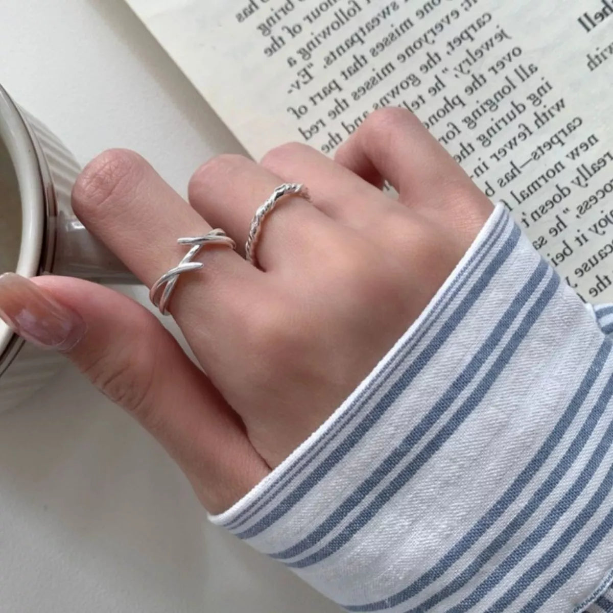 Model stacking the open ring with other silver rings for bold hand styling