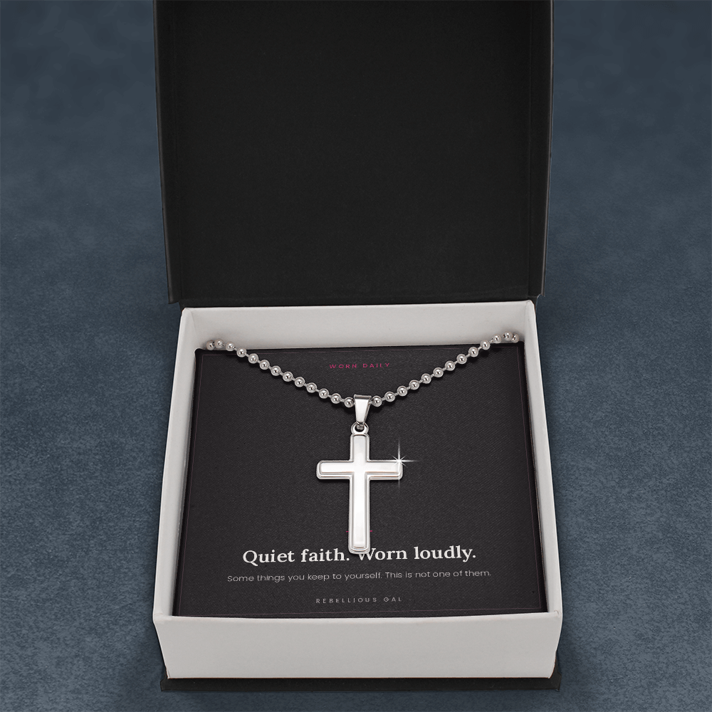 Open black gift box with lid upright, steel cross necklace on the message card