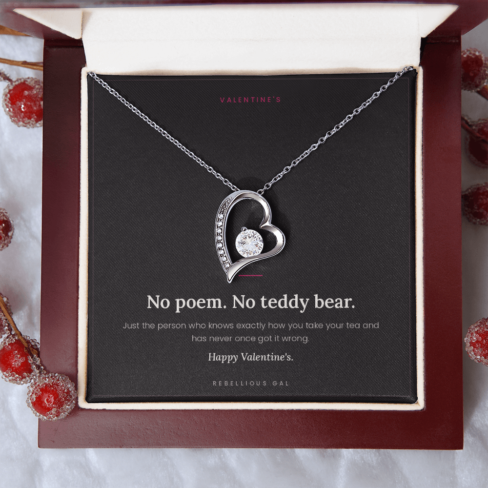 White gold heart pendant and card in the mahogany box beside red berry sprigs