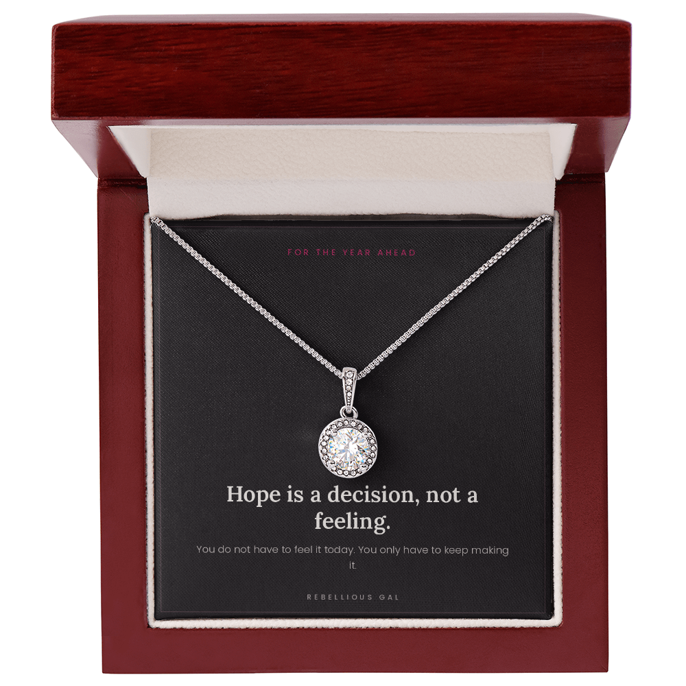 Silver halo pendant necklace on the black message card inside an open mahogany gift box