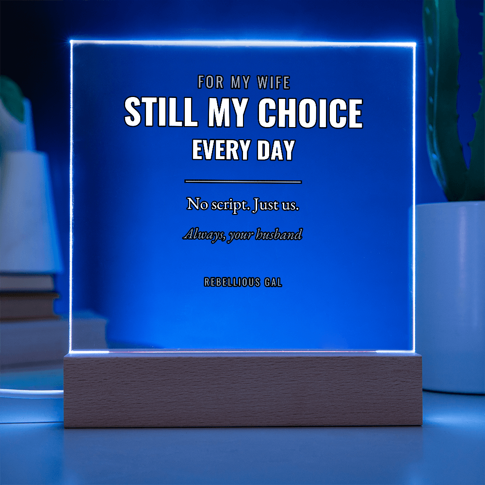 Blue light floods the panel from its edges, a potted plant blurred at right
