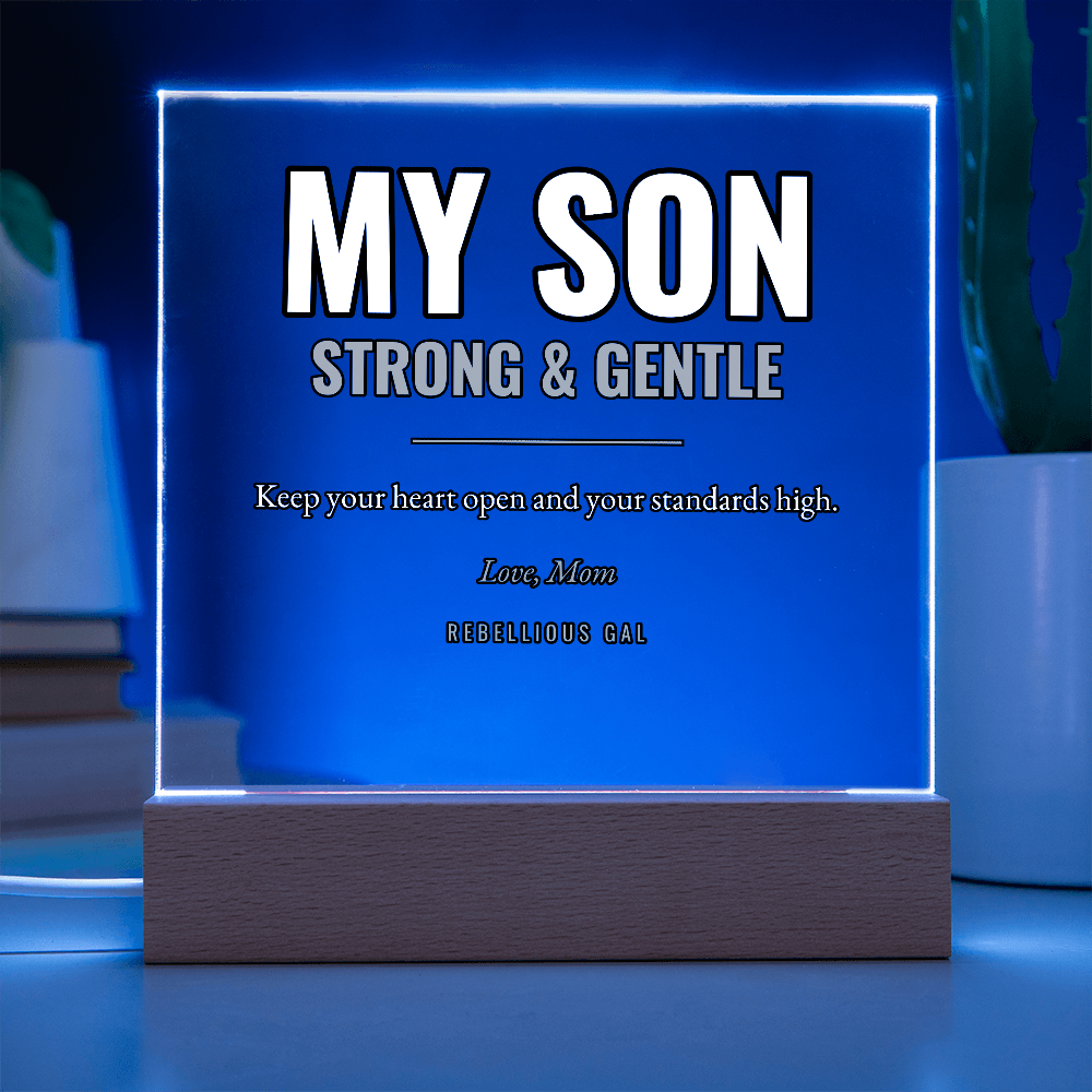 Dark room, the panel edge-lit blue, a thin inset rule framing the engraved lines