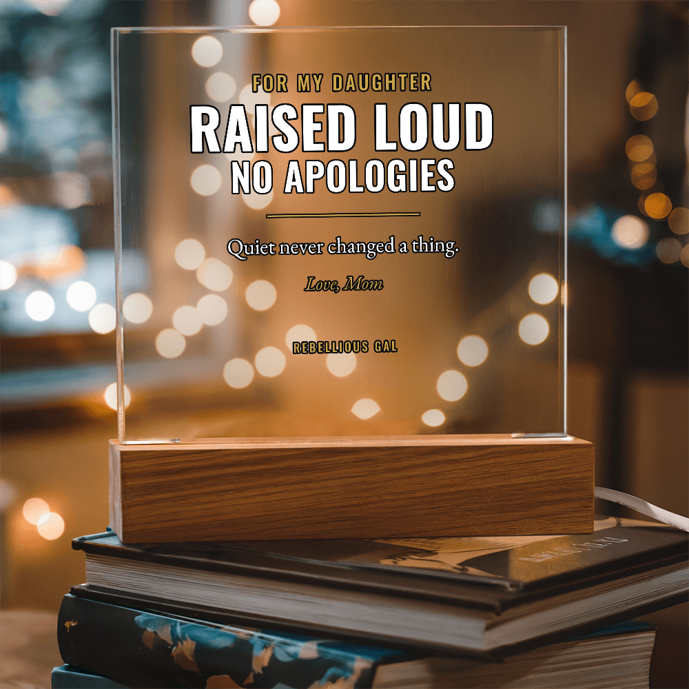 Raised Loud panel in its wood block on books, golden bokeh behind
