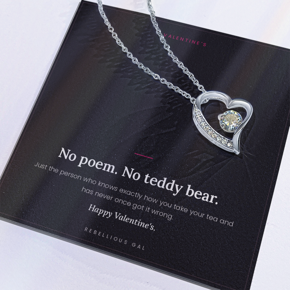 aClose-up of the silver heart pendant resting on the No Poem Valentine's card