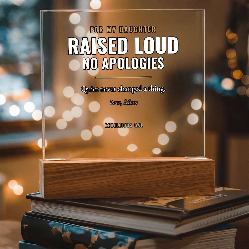 Clear lettered panel in honey wood rests on stacked books, golden bokeh behind