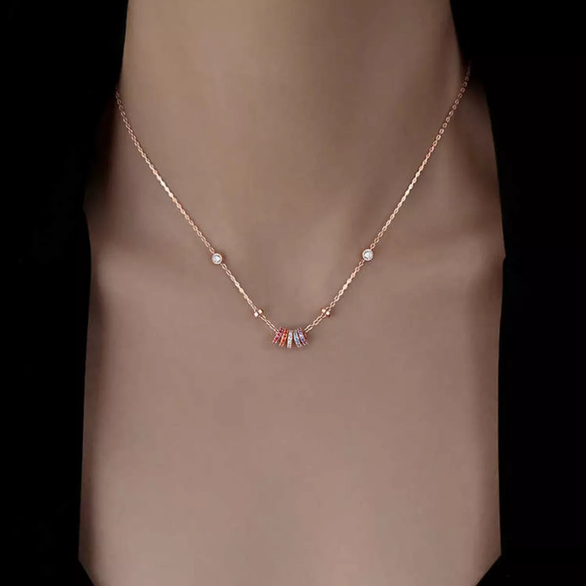 Model layering the rose gold zircon necklace with other bold chains