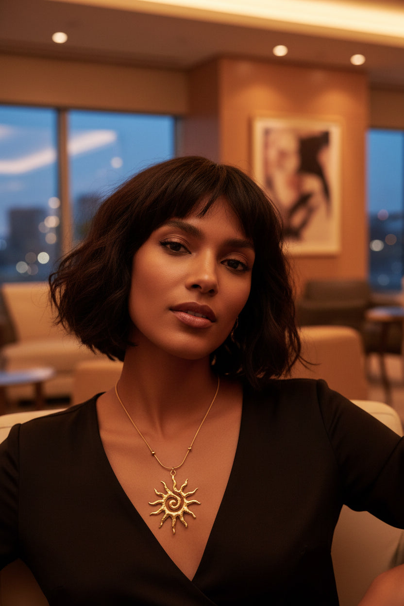 Gold sun-shaped pendant on a chain on a model in a lounge 