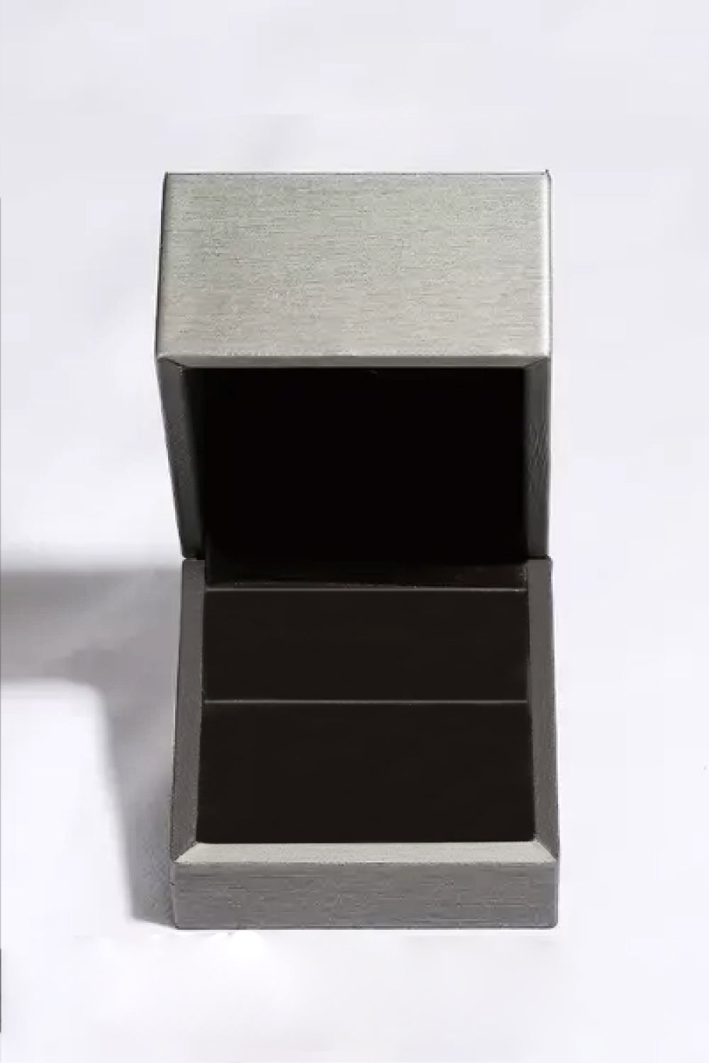 Product flat lay of moissanite ring arranged with matching luxury box