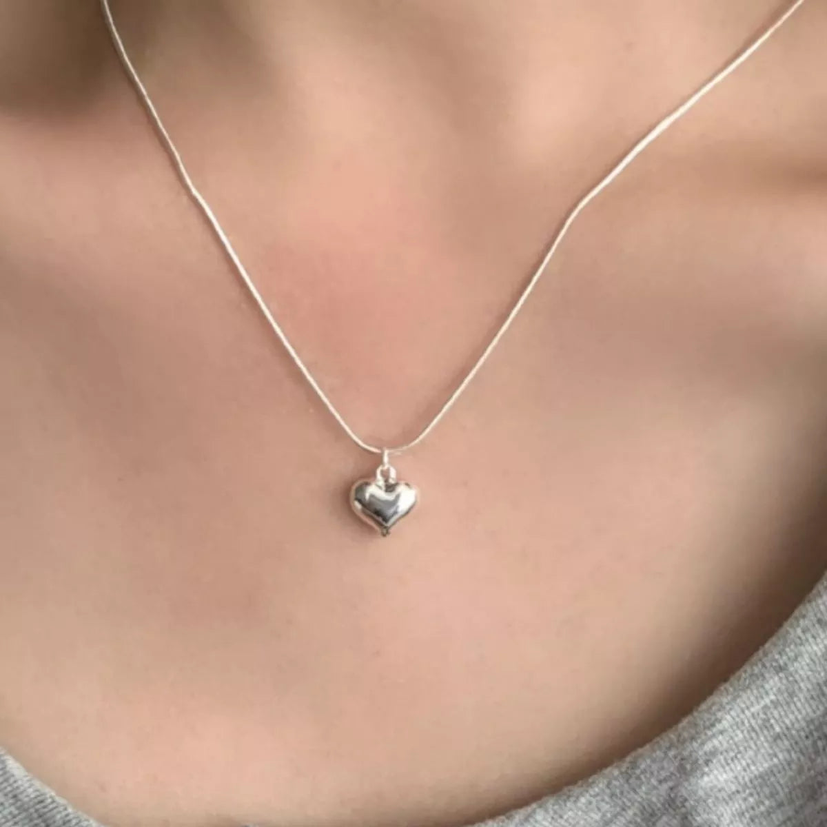 Lifestyle image of heart necklace with casual outfit