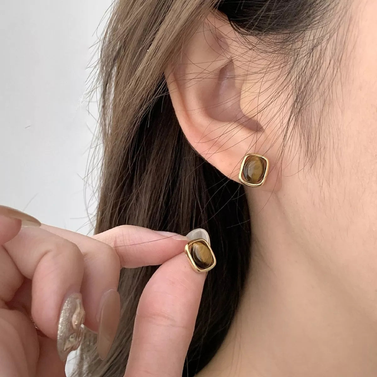 Rebellious Gal tiger eye stud earrings worn on model ears minimalist look