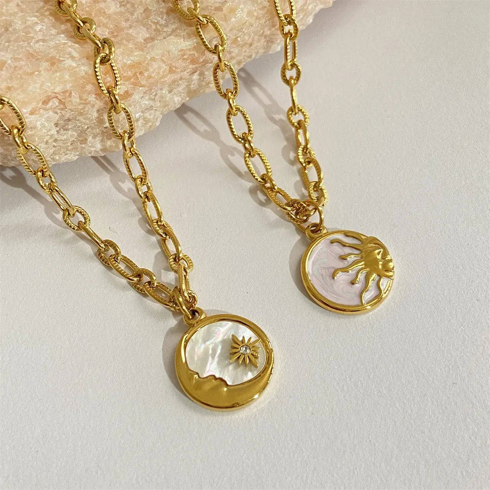 Two gold necklaces with circular pendants on a light background
