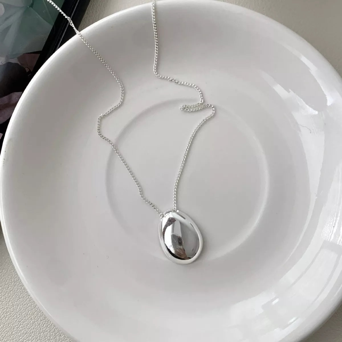 Detail shot of polished 925 sterling silver pendant and chain texture 