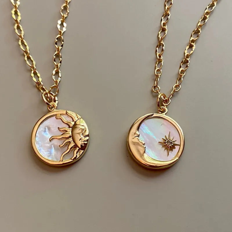 Two gold necklaces with circular pendants featuring celestial designs on a neutral background.
