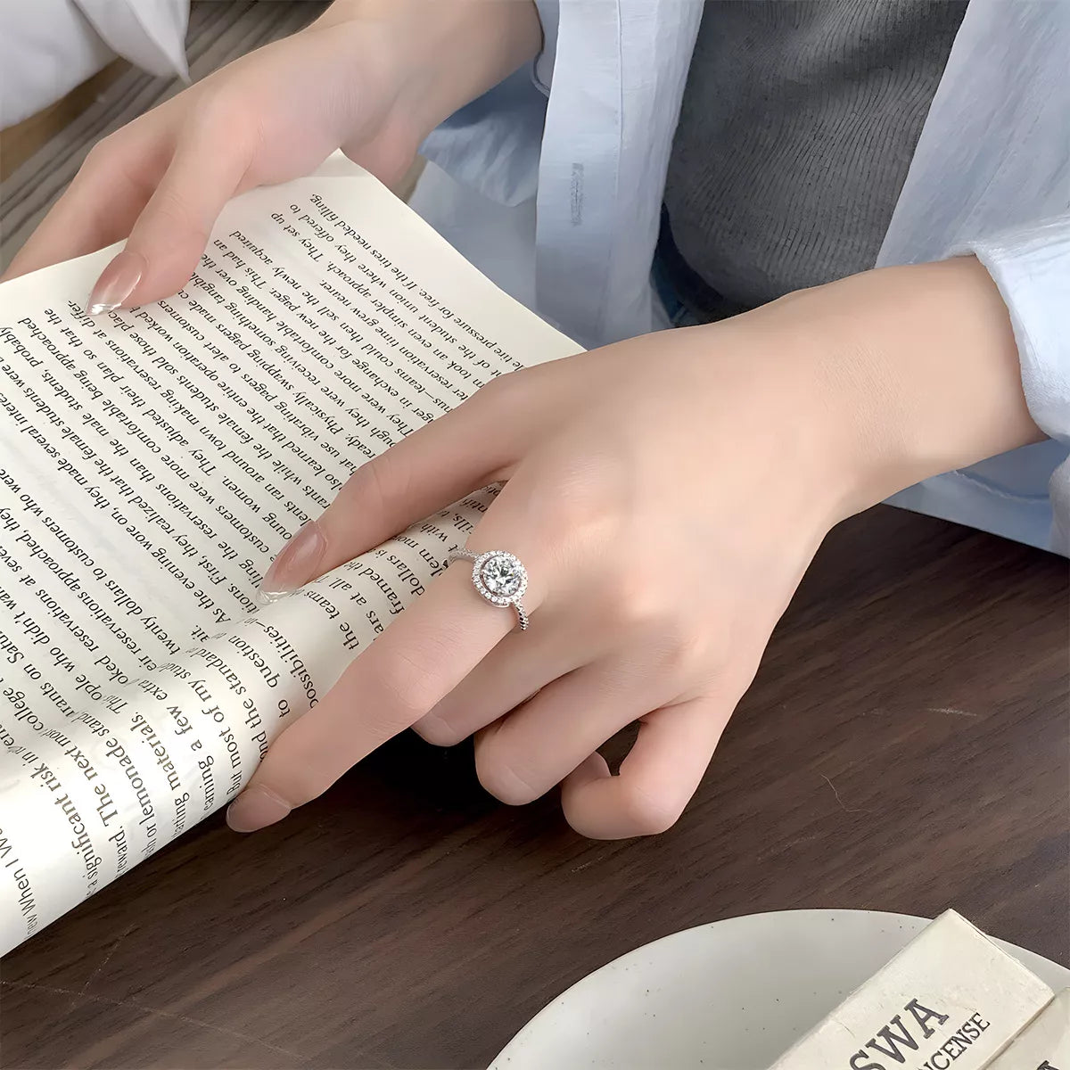 Model stacking the moissanite ring with other bold silver rings