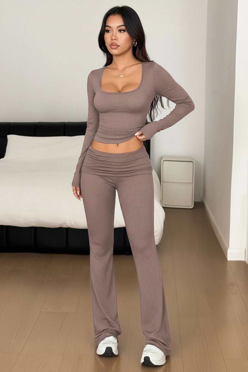Woman wearing a brown long-sleeve top and pants set in a room.