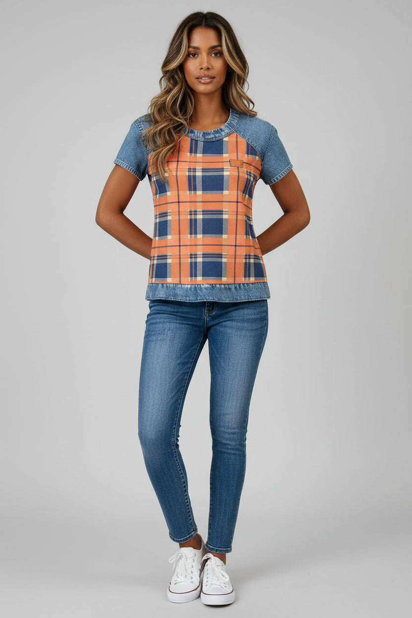 Woman wearing a plaid shirt with denim sleeves and pants on a plain background