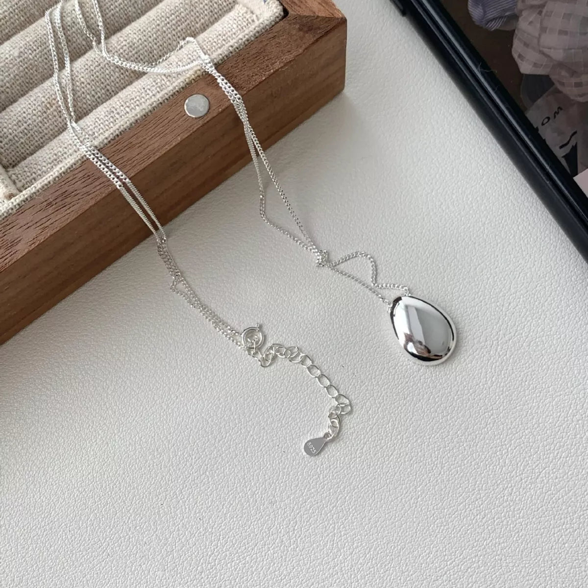 Detail of minimalist pendant design and secure bail on sterling silver chain