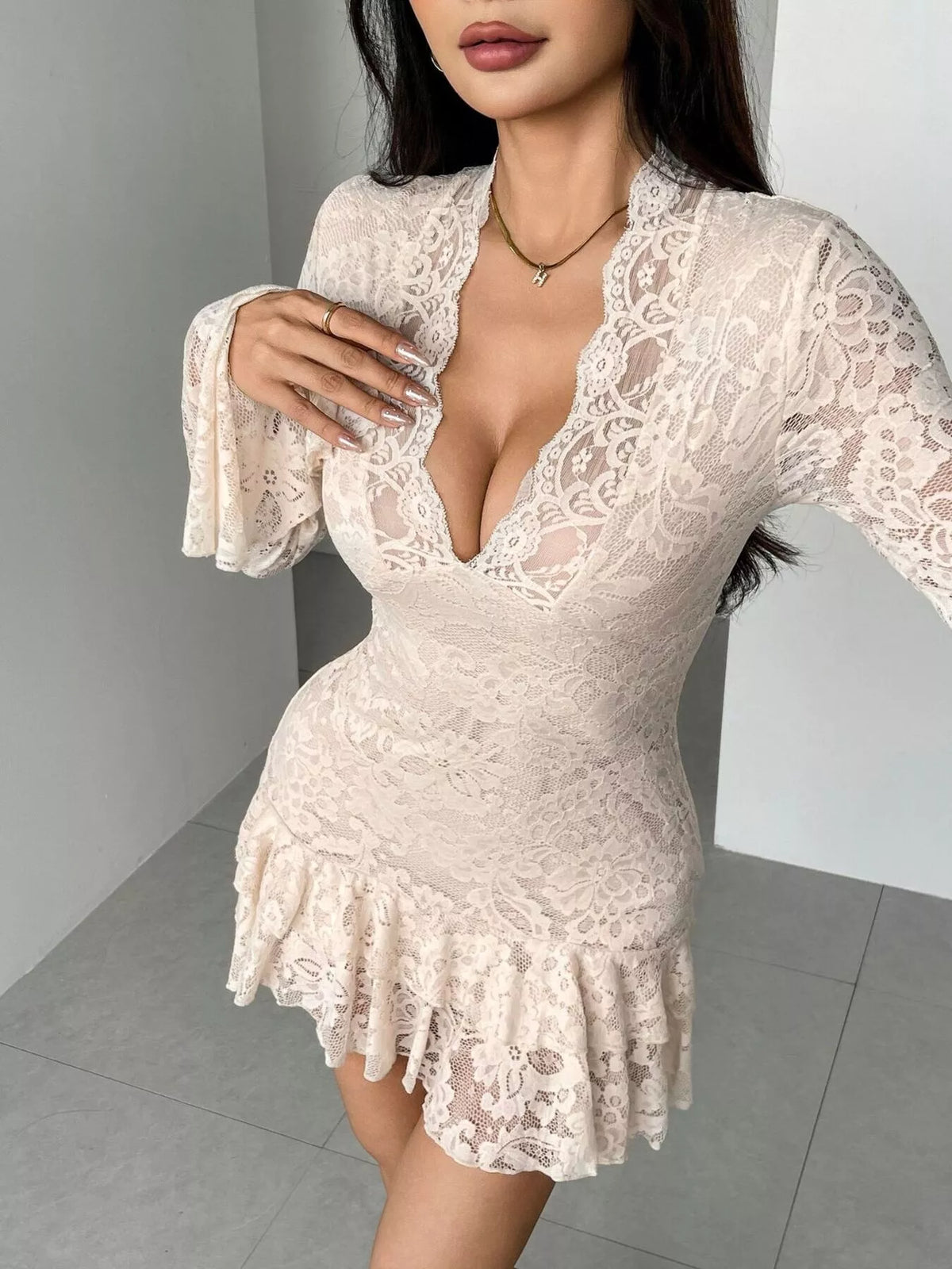 Woman wearing a white lace dress against a neutral background