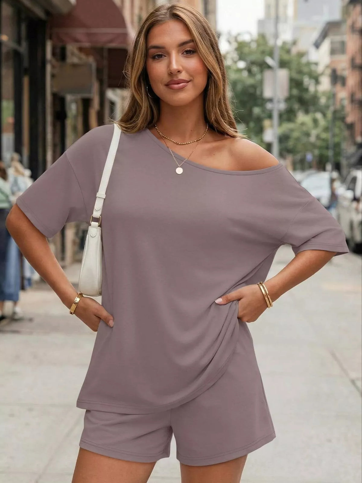 Woman wearing a loose-fitting purple outfit on a city street.