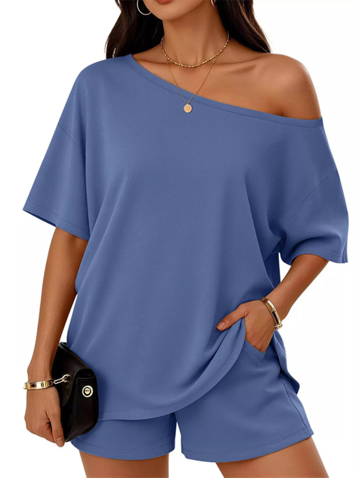 Woman wearing a blue off-shoulder top and shorts set on a white background
