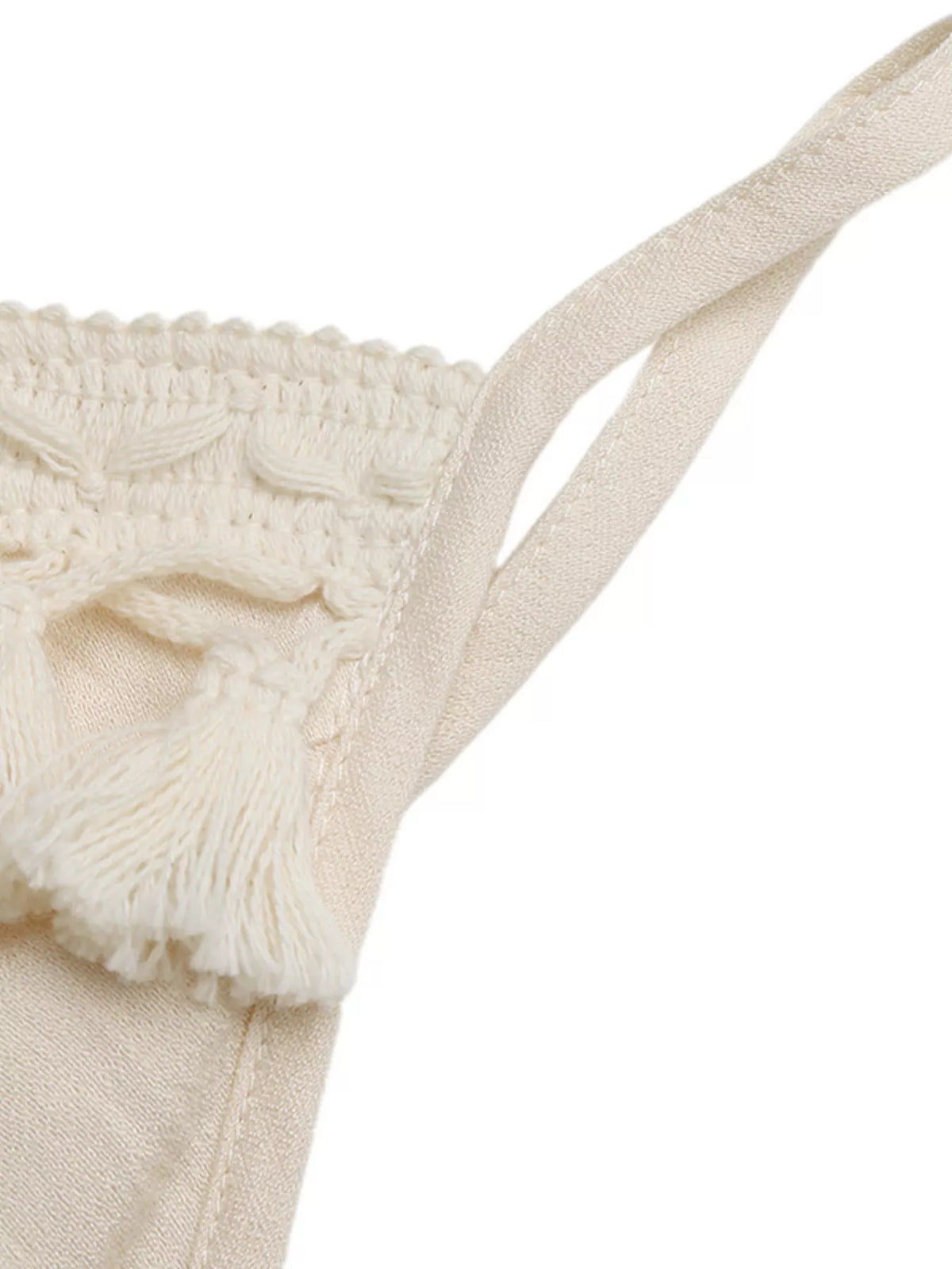 Close-up of a beige knitted bikini top with textured details on a white background