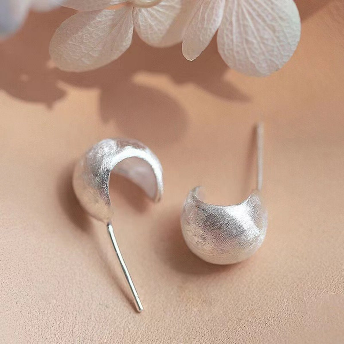 Polished sterling silver C-Hoop Earrings reflecting light