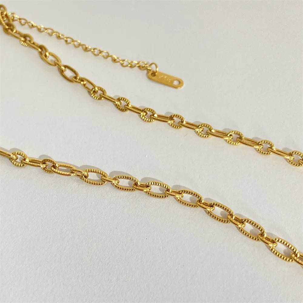 Gold chain necklace on a light gray background