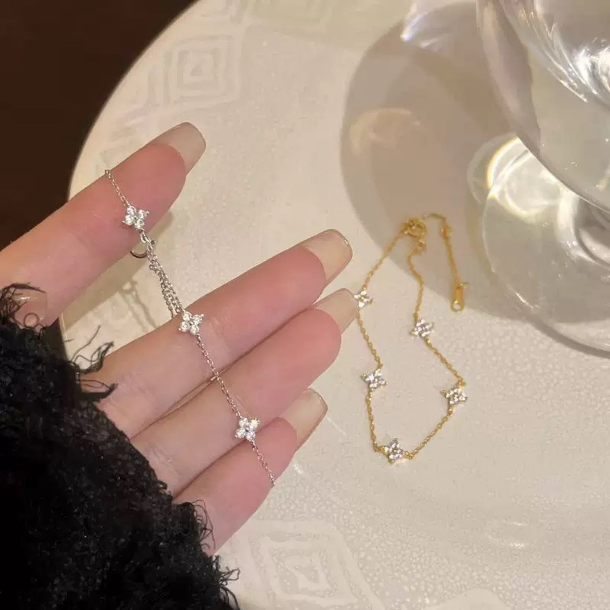 Detail shot of 18K gold-plated four-leaf clover charm and zircon accents