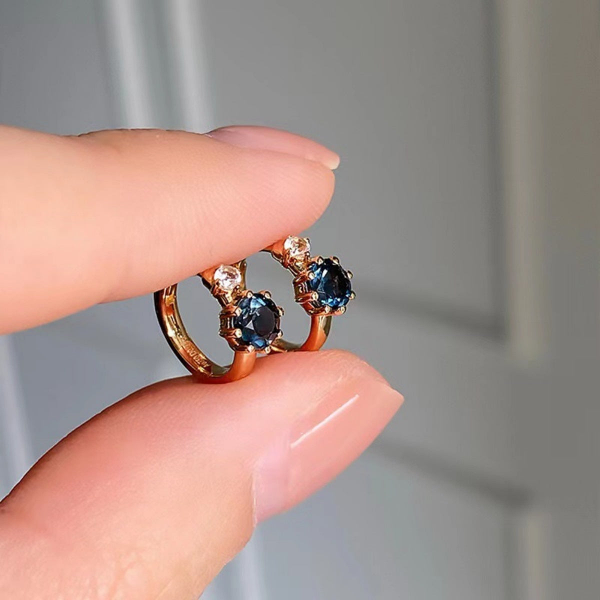 Side profile of delicate 0.4" gold-plated zircon hoop earrings showing thin design