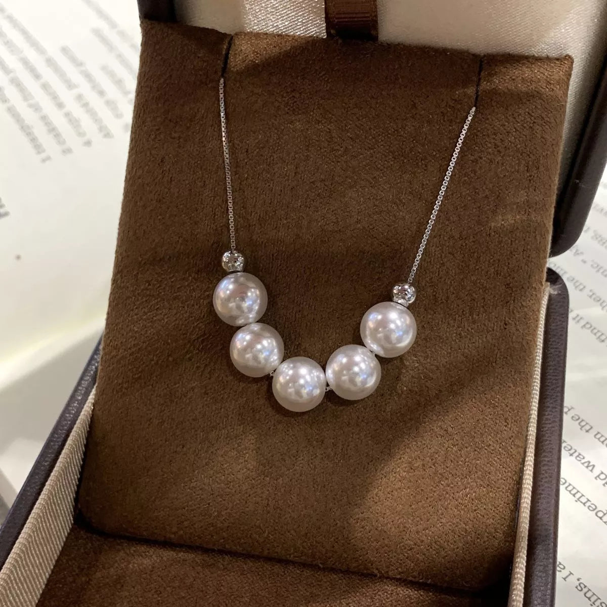 Pearl necklace on a brown cushioned stand