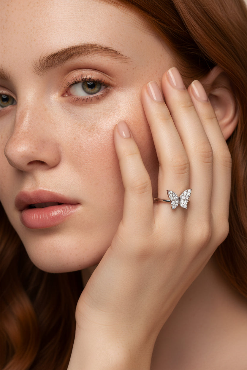 Silver butterfly-shaped ring on freckled face red hair model