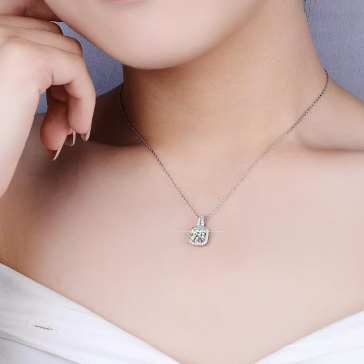 Model layering the moissanite pendant with other bold chains