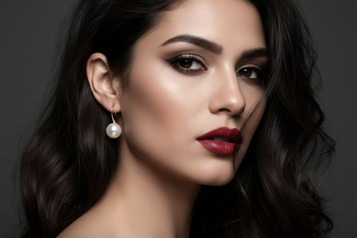 Pearl earrings with gold hooks on a latino model