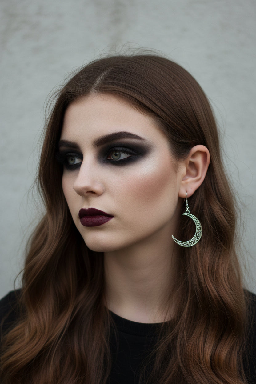 Close-up of a person wearing a silver crescent moon earring.