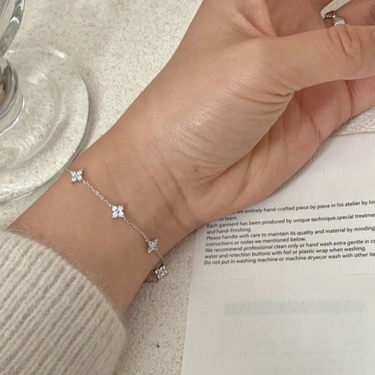 Model wearing Rebellious Gal four-leaf clover bracelet with rebellious layered jewelry look